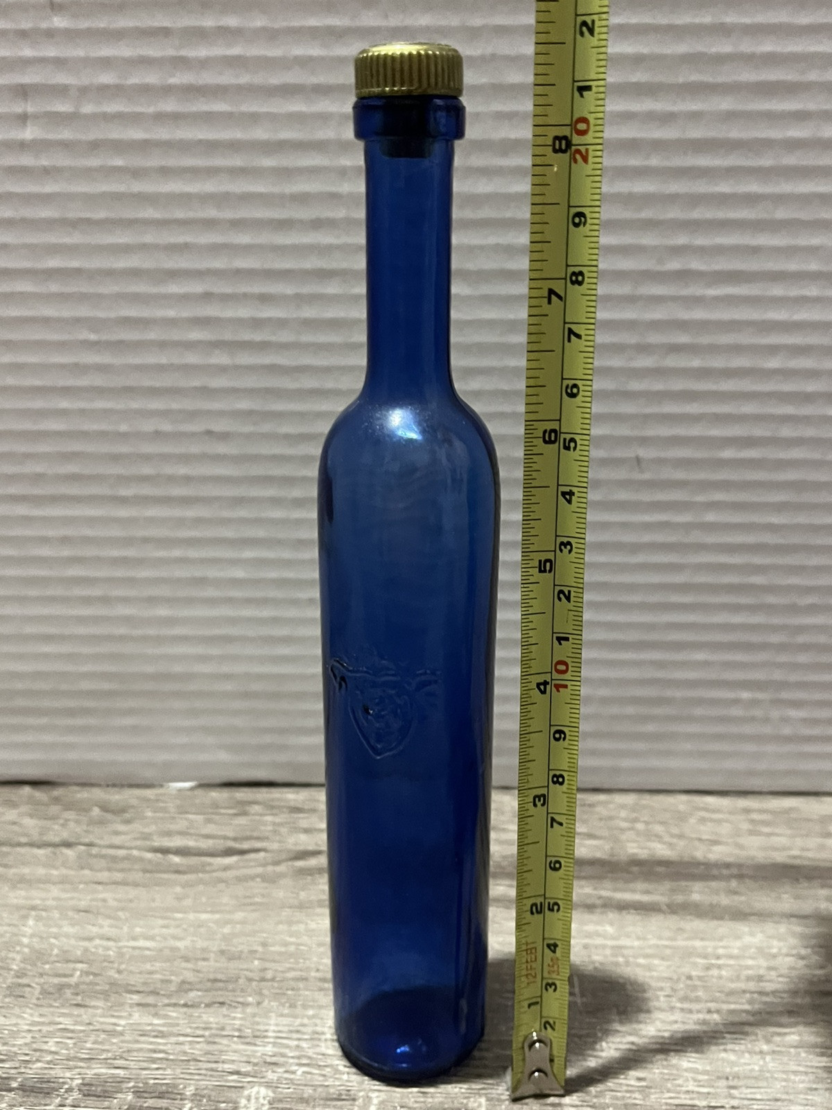 8.5″ Tall x 1.5″ Cobalt Blue bottle – plastic cap w/cork – Coat of Arms, Signed