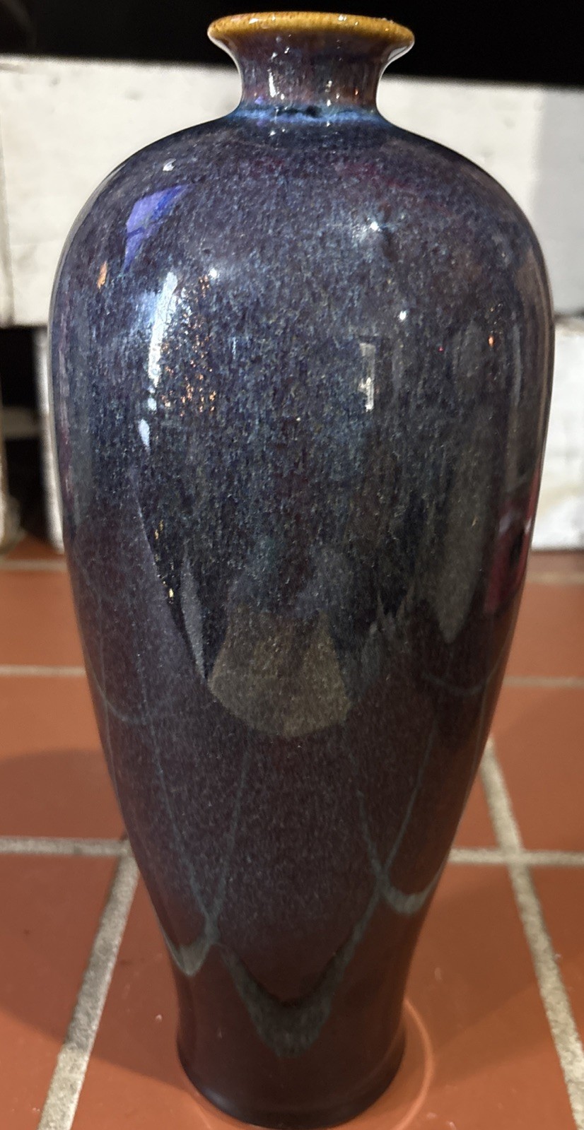 A tall, mottled purple-blue glazed ceramic vase with a contrasting rim.