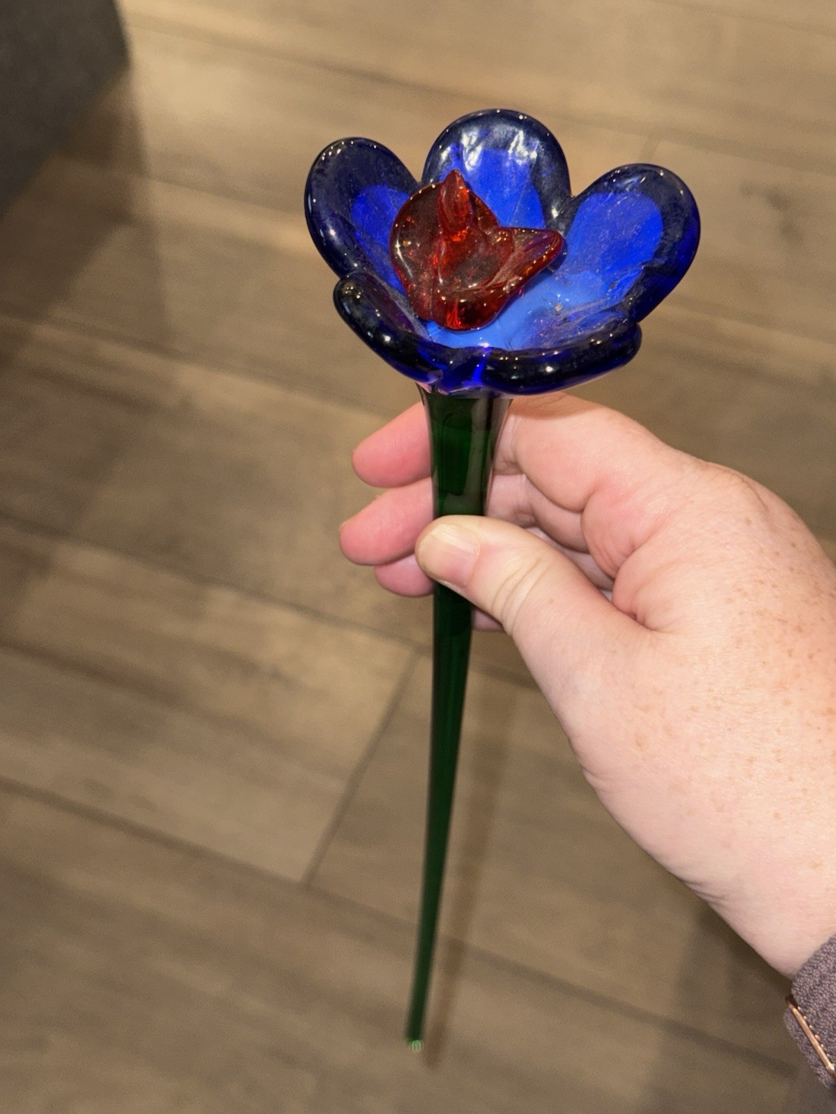 Hand-blown art glass flower with blue petals and a red center