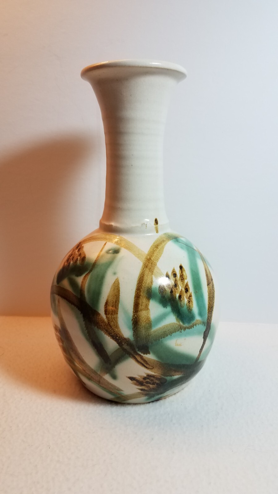 Pottery vase cream and green 10 inches tall 5 inches in diameter