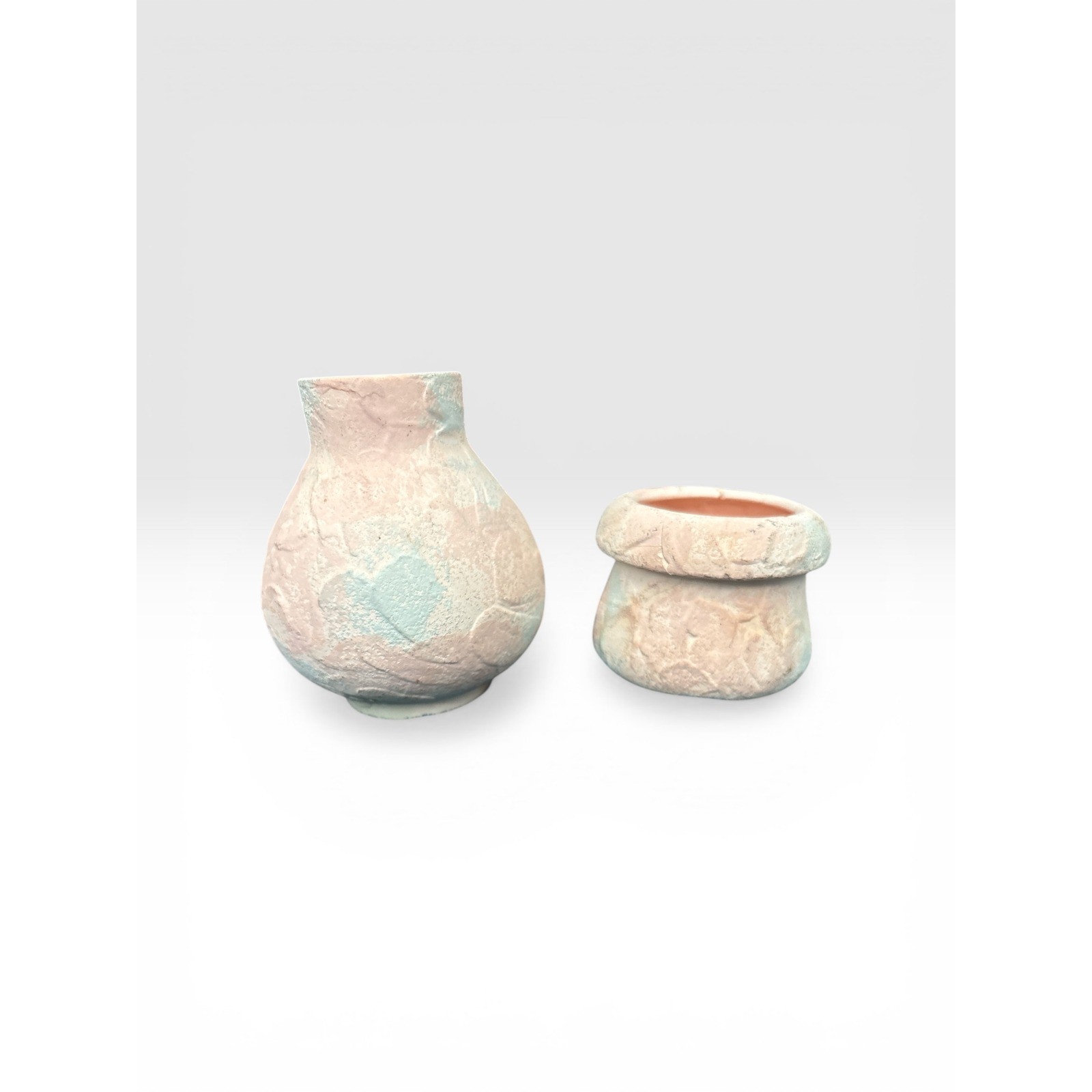 Pottery two piece white with pink and blue accents about 3.5 inches
