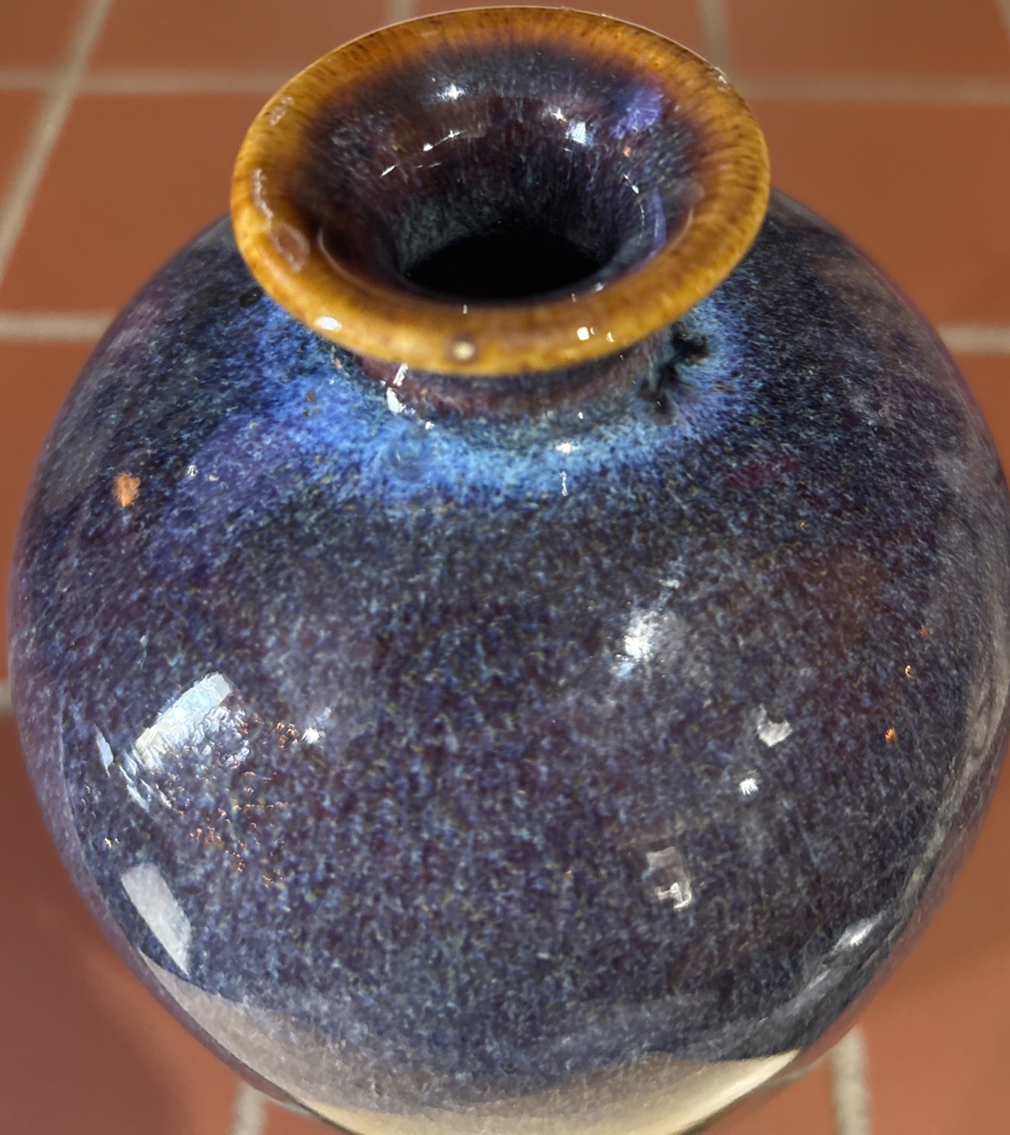 A tall, mottled purple-blue glazed ceramic vase with a contrasting rim.
