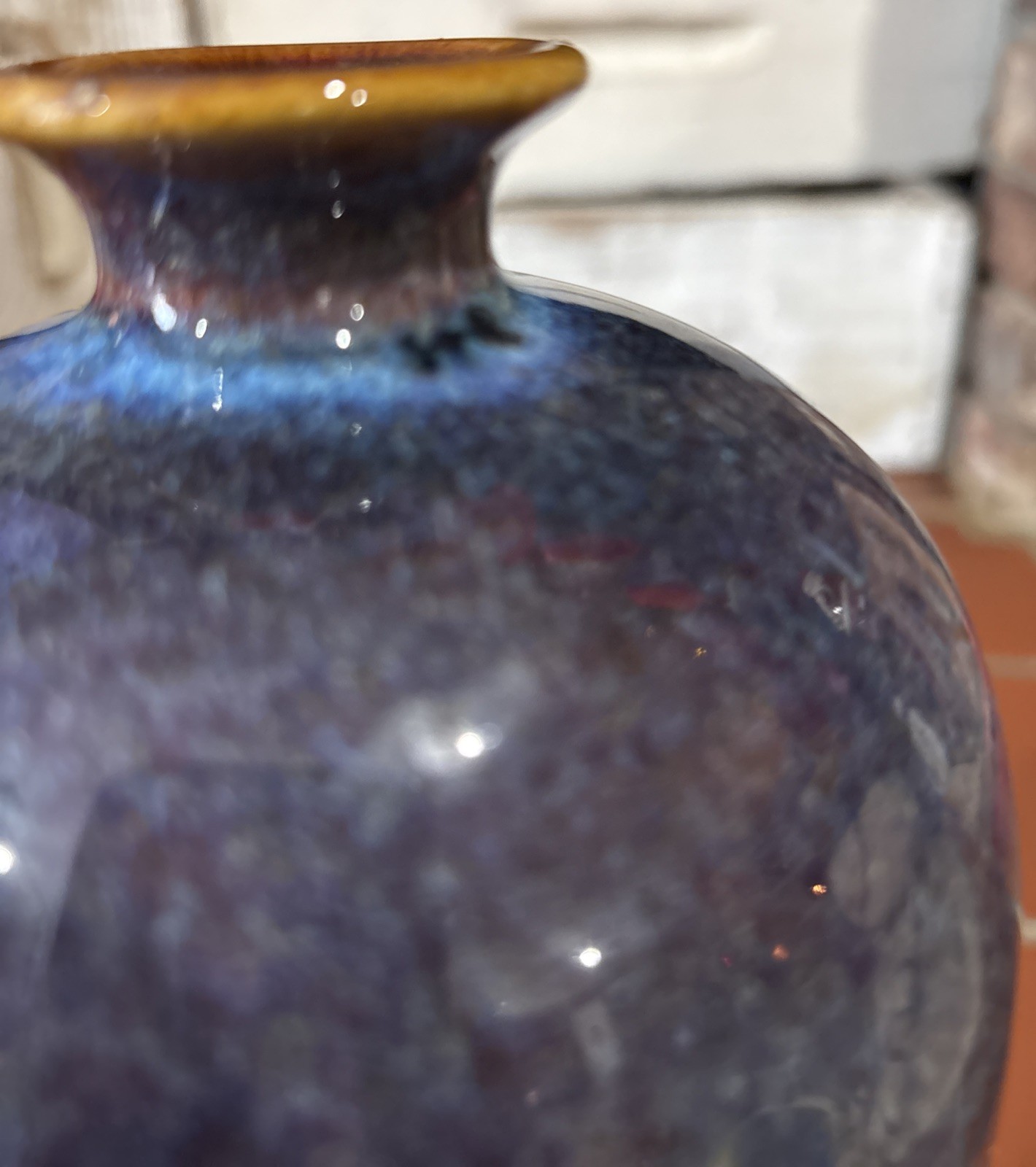 A tall, mottled purple-blue glazed ceramic vase with a contrasting rim.