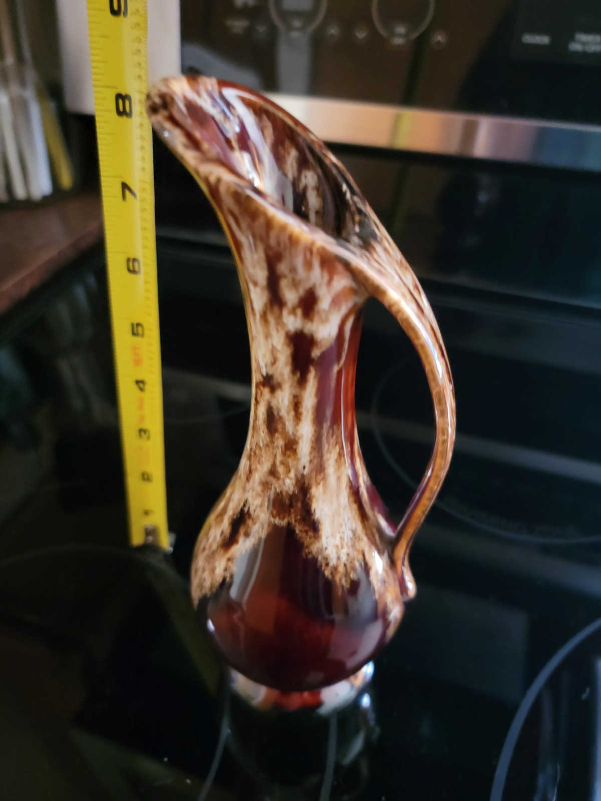 A mid-century American ceramic ewer with a brown and cream drip glaze.